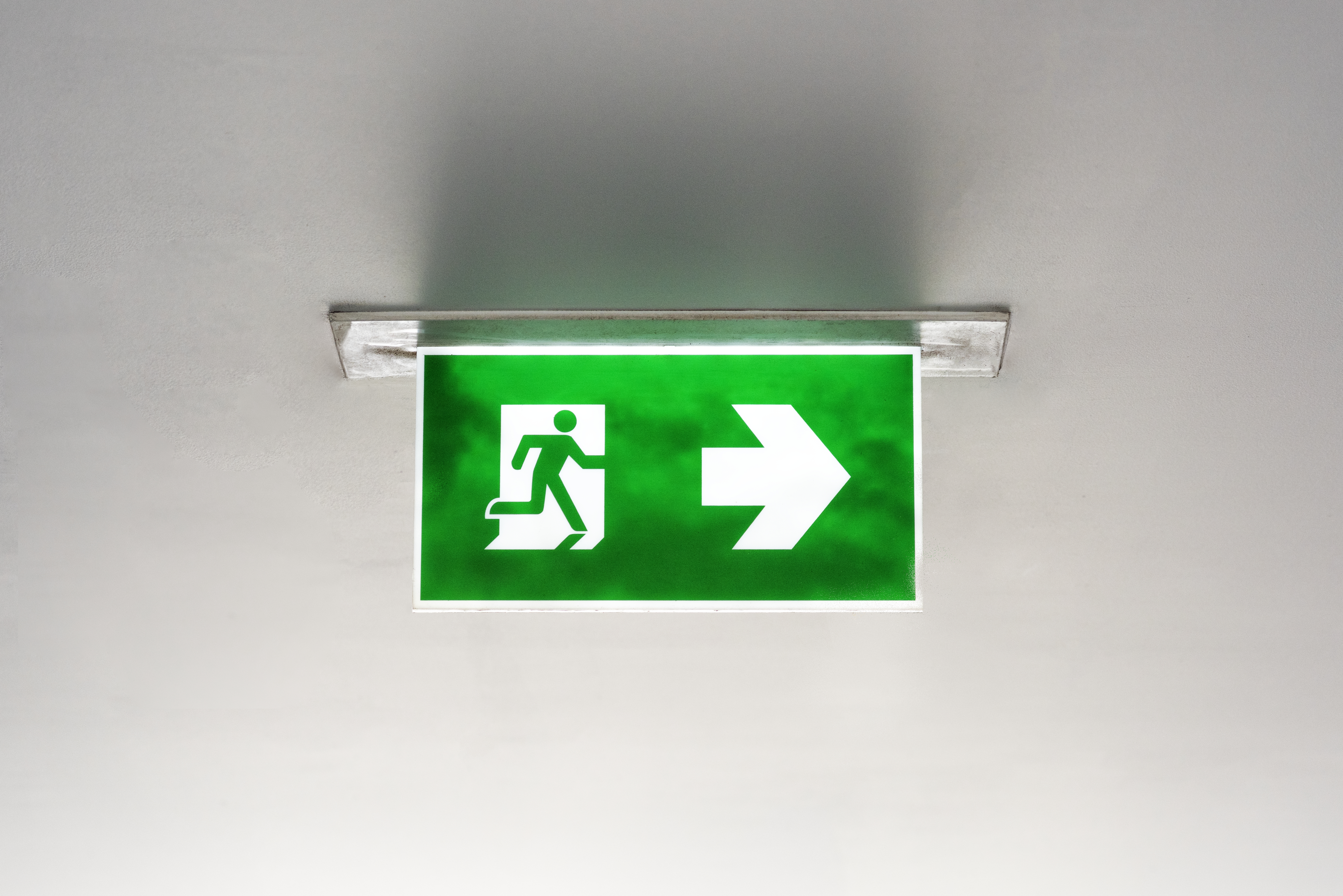 Green emergency exit sign on the ceiling